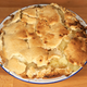 Ugly, badly made Apple Pie on wood countertop
